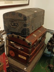 Old suitcases and chests stacked, taken in a heritage railway station.