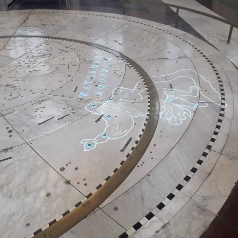 Marble floor with ancient map and illustrations projected on as if globe. From Citizen's Hall in Amsterdam Palace.