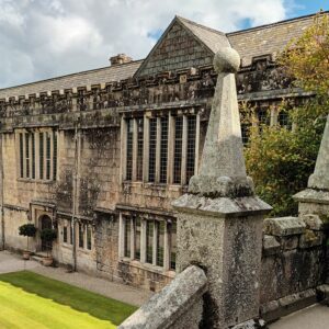 Stone steps down to a formal lawn in front of a grand stone building - National Trust Landhyrock House.