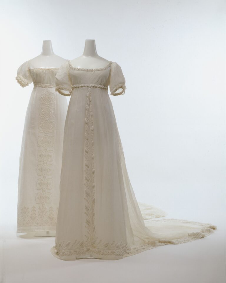 Two white floaty dresses with empire waistlines (under bust), with puffed sleeves and trains.