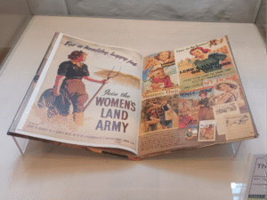 WWII poster book open in display case to the Women's Land Army art