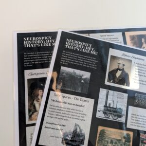 Two laminated handouts from Neurospicy History: That's Like Me! Workshop are visible. They have a black background and collage effect with different stories and illustrations.