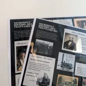 Two laminated handouts from Neurospicy History: That's Like Me! Workshop are visible. They have a black background and collage effect with different stories and illustrations.